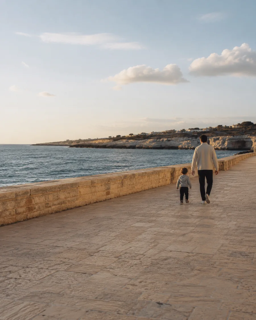 An adult and a child walking along a promenade